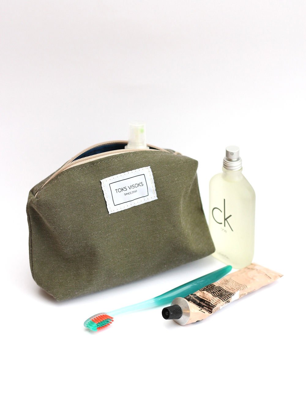 3. Studio shot of TOKS VISOKS LORNA Makeup Bag in army green with toiletries, showing flexible structure