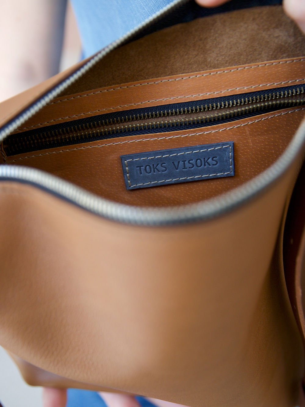5. Interior view of TOKS VISOKS ROBIN leather handbag in camel brown, showing brand label and zipper