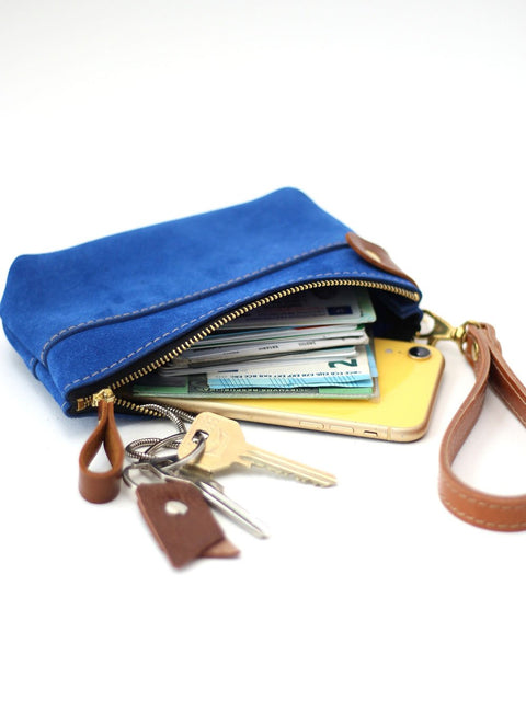 2. Blue suede POUCH wallet by TOKS VISOKS, featuring zipper closure and brown leather strap, filled with essentials