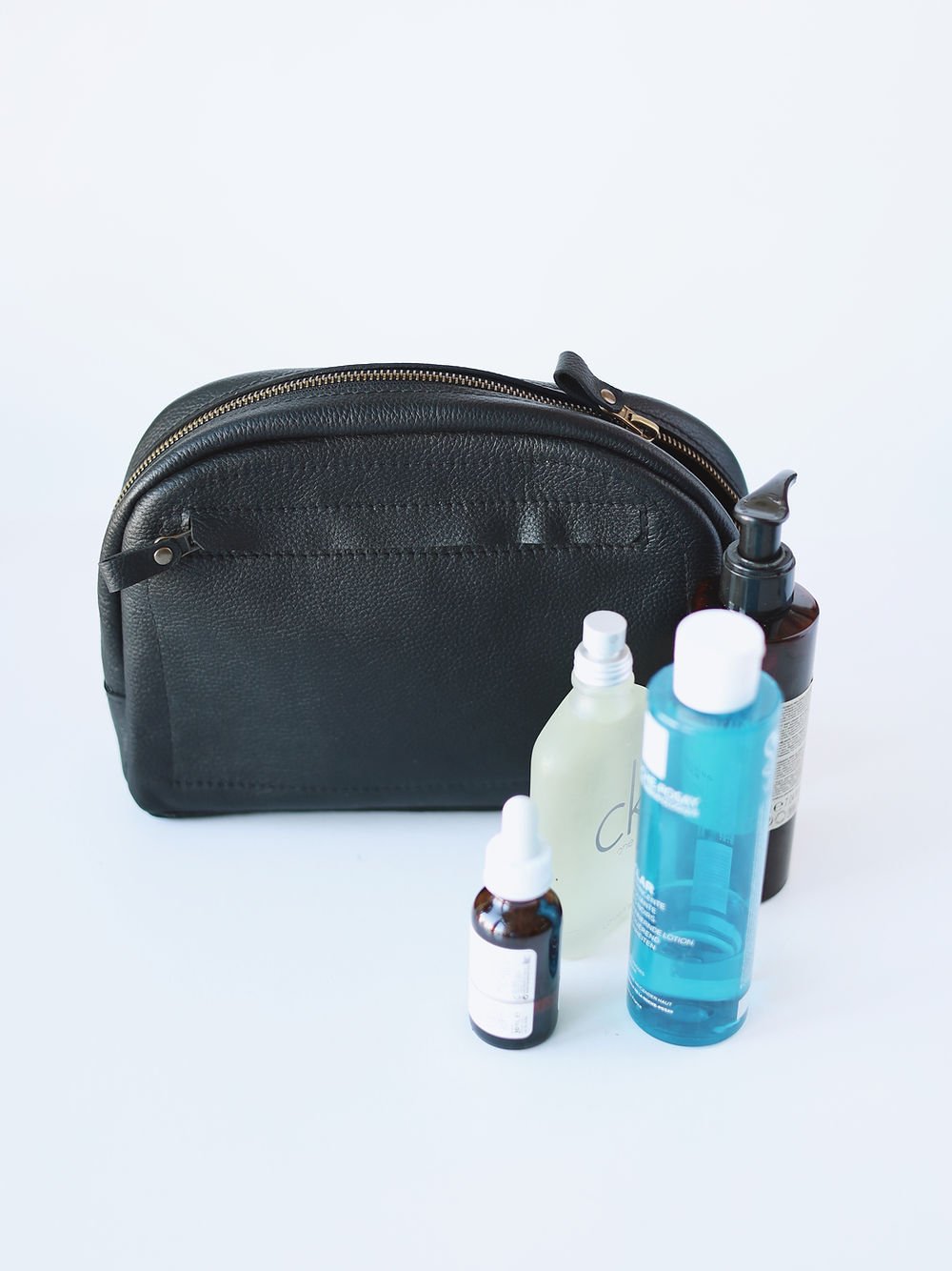 2. Black leather toiletry bag by TOKS VISOKS with toiletries, highlighting spacious design