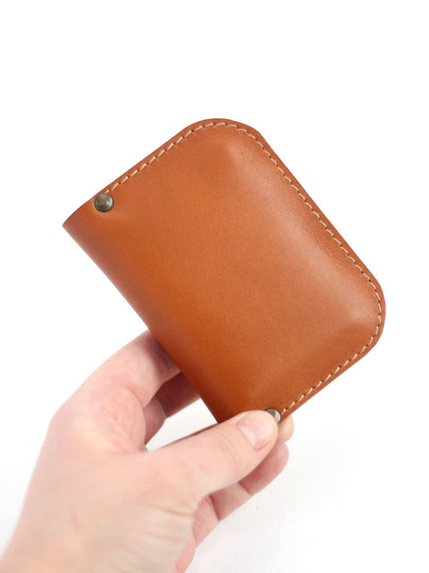 5. Hand holding closed SUNDAY Wallet in caramel by TOKS VISOKS, showcasing compact size