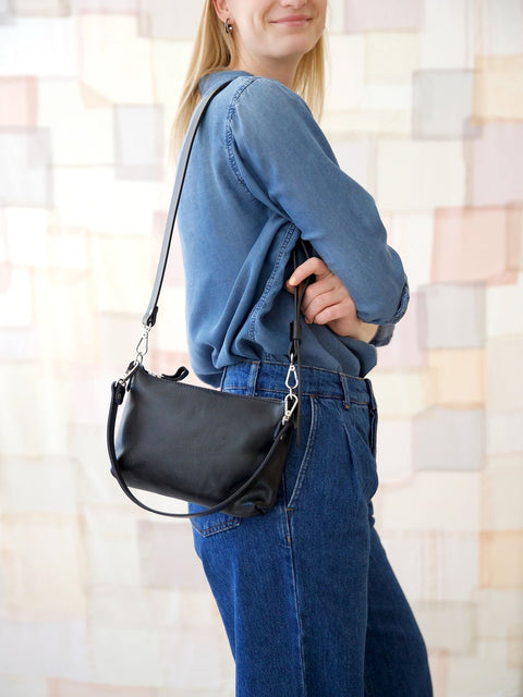 2. Women's black TOMMY leather bag by TOKS VISOKS worn on shoulder, side view in lifestyle setting