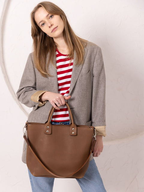 5. Woman holding MIGLE Leather Handbag in cappuccino by TOKS VISOKS, showcasing long strap