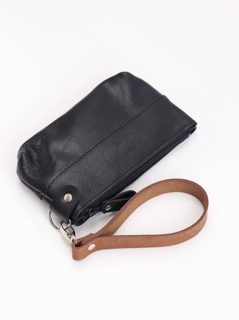 3. Studio shot of TOKS VISOKS black POUCH wallet highlighting recycled leather and brown wrist strap