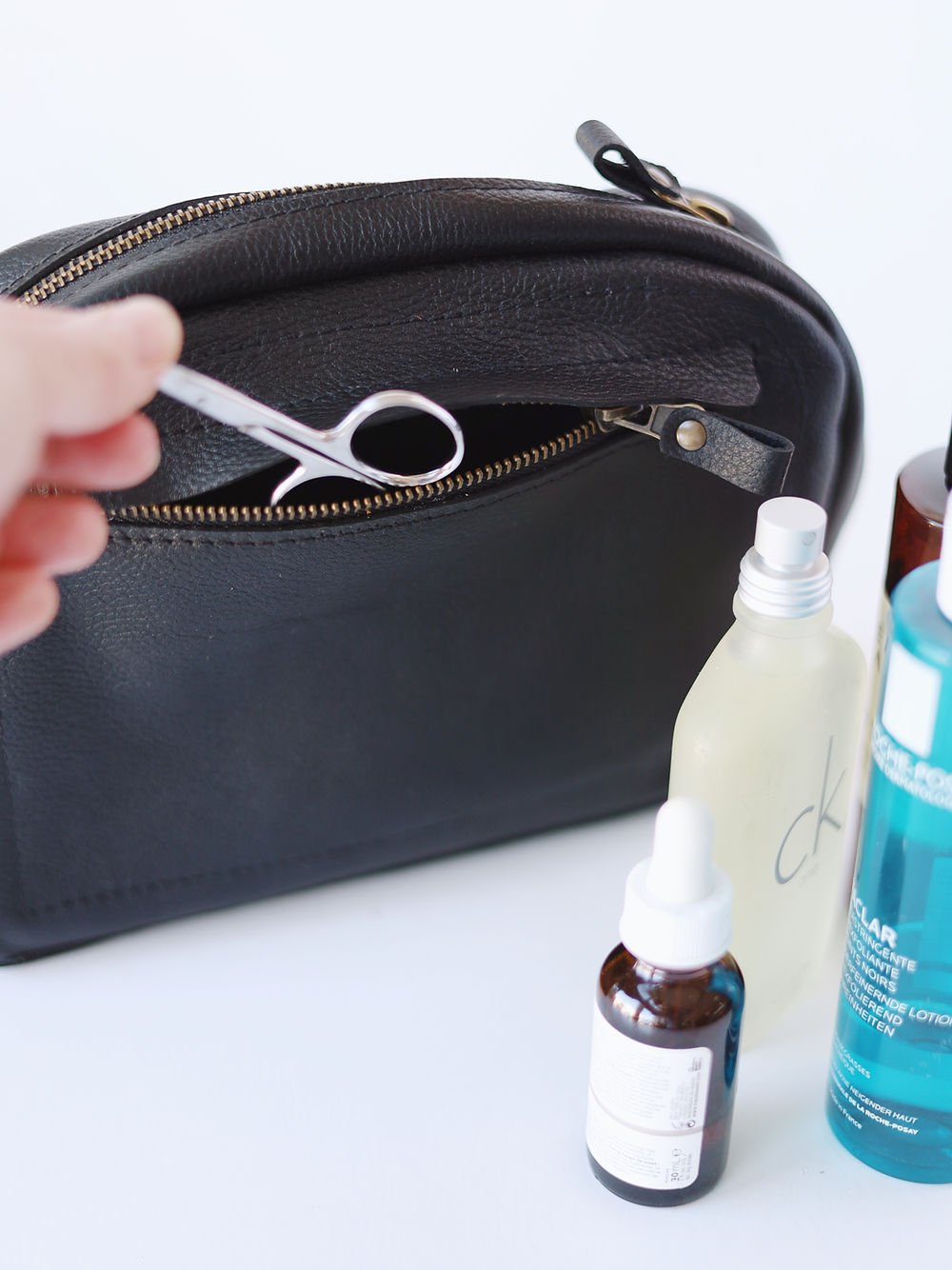 4. Close-up of TOKS VISOKS toiletry bag with scissors in front pocket, emphasizing functionality