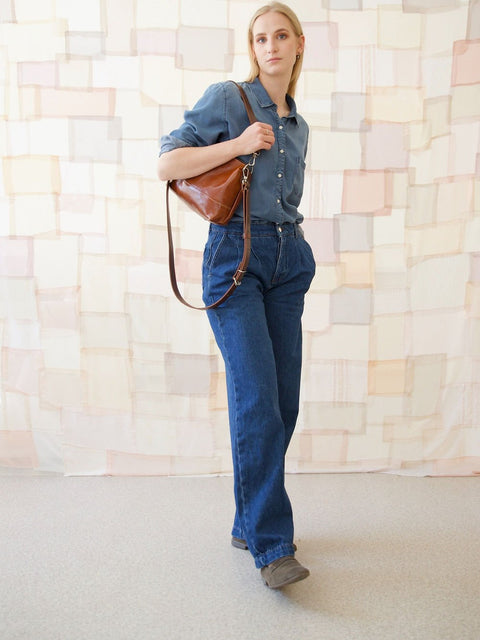 4. Woman carrying TOKS VISOKS ROBIN leather handbag in ginger brown, styled with casual denim outfit
