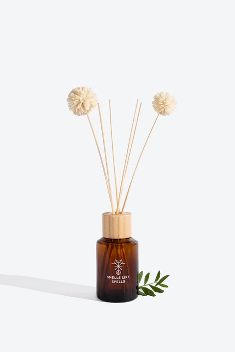 3. Smells Like Spells Thor home perfume with decorative reeds and green leaf accent, studio setting