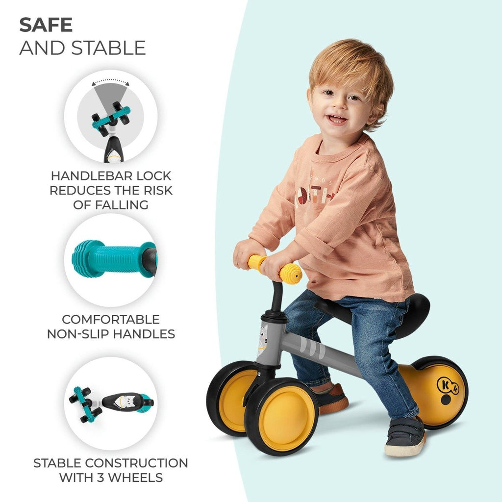 1. Child riding yellow Kinderkraft CUTIE balance bike with safety features highlighted
