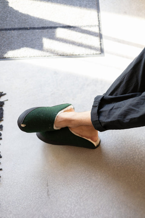 2. Unisex dark green TOKU Brussels slippers by Omaking worn by a man on a light floor