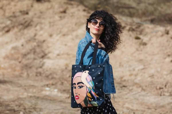 1. Women's black HANDBAG SIUZANA by Garbanota with artistic print, worn by model in studio