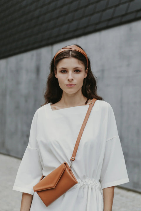 1. Women's brown leather waist and shoulder bag by Gerda Retter Design, worn crossbody in urban setting