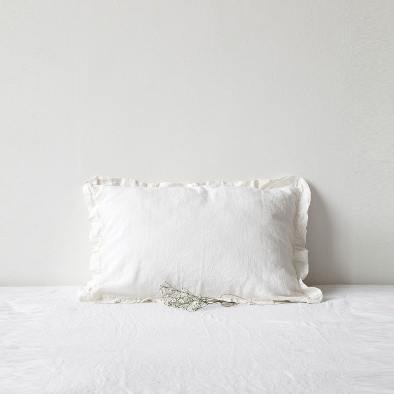 4. White linen pillowcase with frills on a white bed, minimalistic bedroom decor