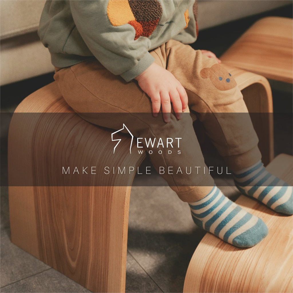 5. Ewart Woods logo over child sitting on wooden step stool with striped socks