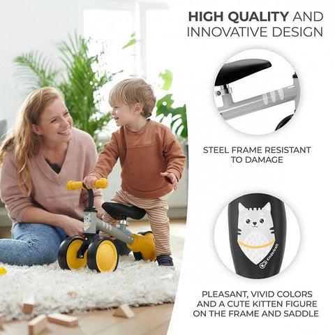 4. Child playing with yellow Kinderkraft CUTIE balance bike featuring steel frame and kitten print indoors
