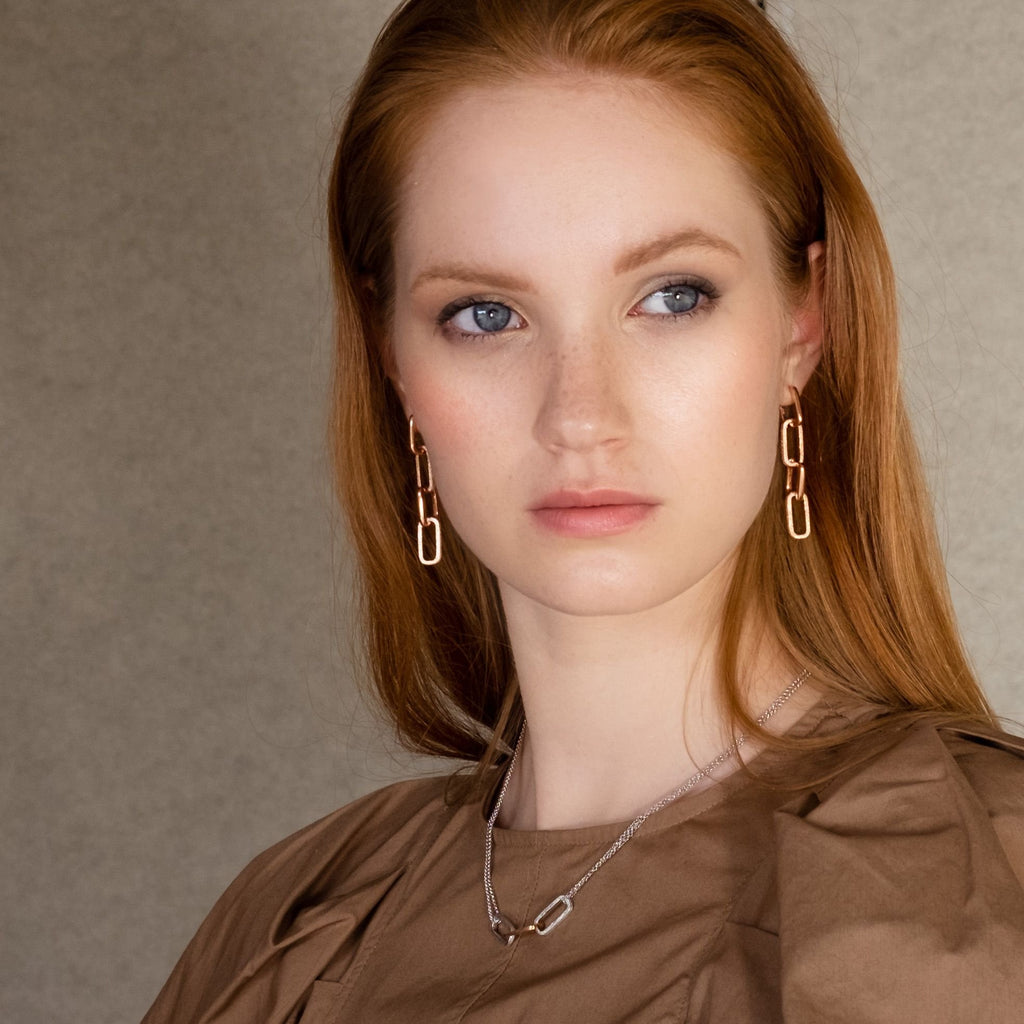 1. Woman wearing MyaMoon Metropolitan necklace in lifestyle setting, showcasing rhodium-plated 925 silver chain with elegant design