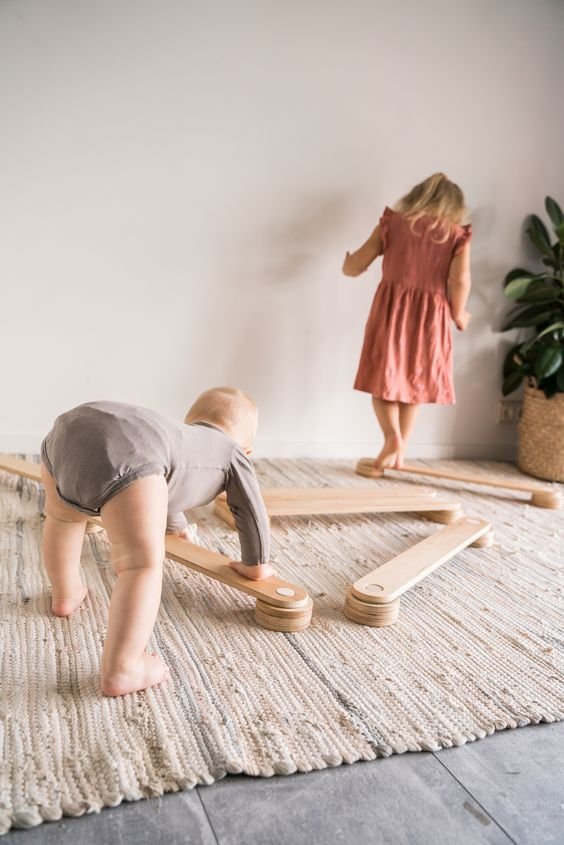 3. Two children playing with Ewart Woods wooden balance beams on a rug