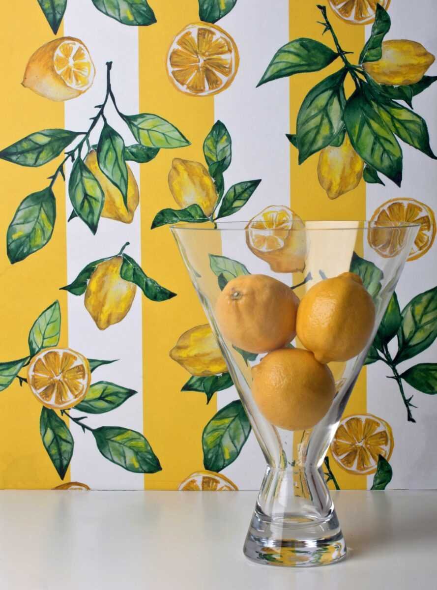 1. Striped lemon wallpaper with lemons in glass vase against yellow and white striped background