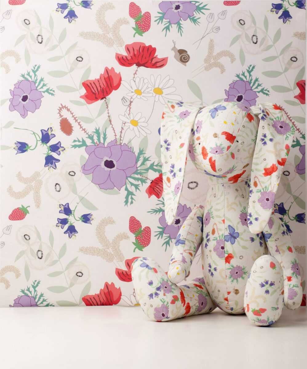 1. Vanilla Meadow eco wallpaper with floral and butterfly pattern in a room setting with a stuffed rabbit toy