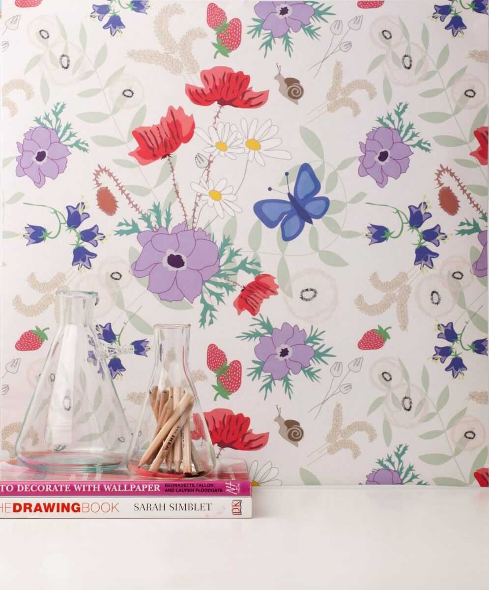 1. Vanilla Meadow eco wallpaper with floral and butterfly pattern in a room setting with glass jars and books