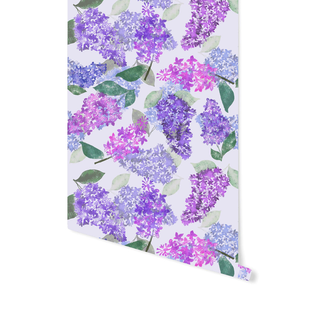 2. Studio shot of Miurio's lilac garden wallpaper roll featuring hand-painted purple and fuchsia lilacs with green leaves