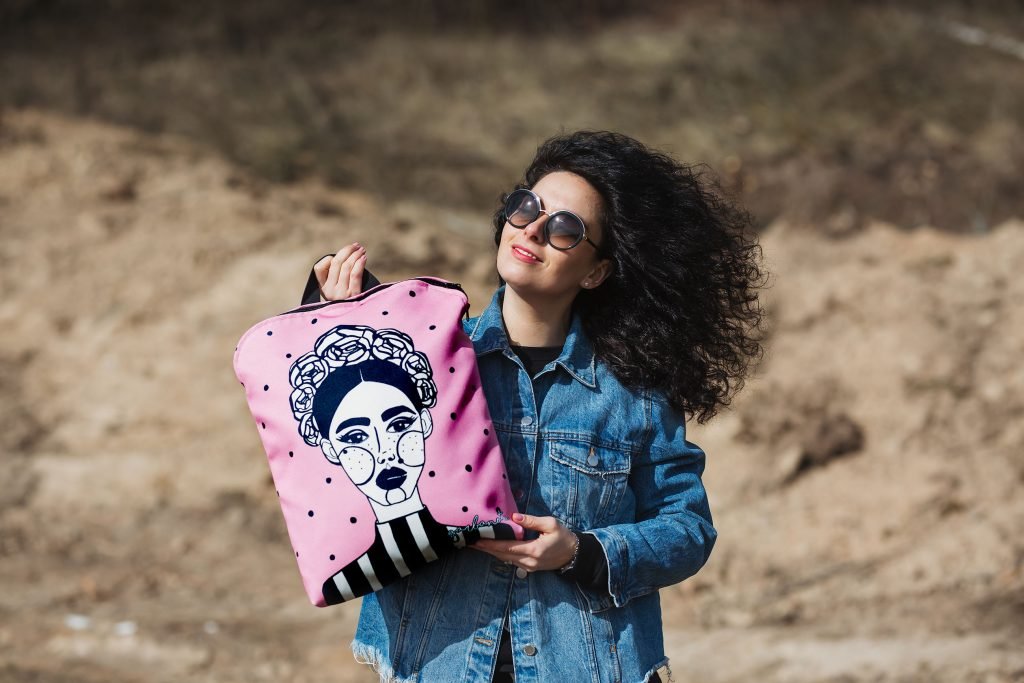 2. Pink MARGO backpack by Garbanota with unique print, held by woman in denim jacket outdoors