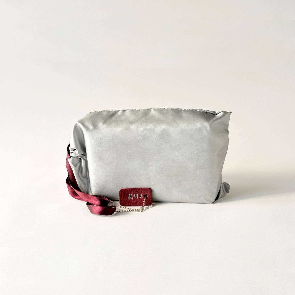 8. Flat lay of Daz Studio burgundy leather envelope bag with adjustable strap and chic chain detail