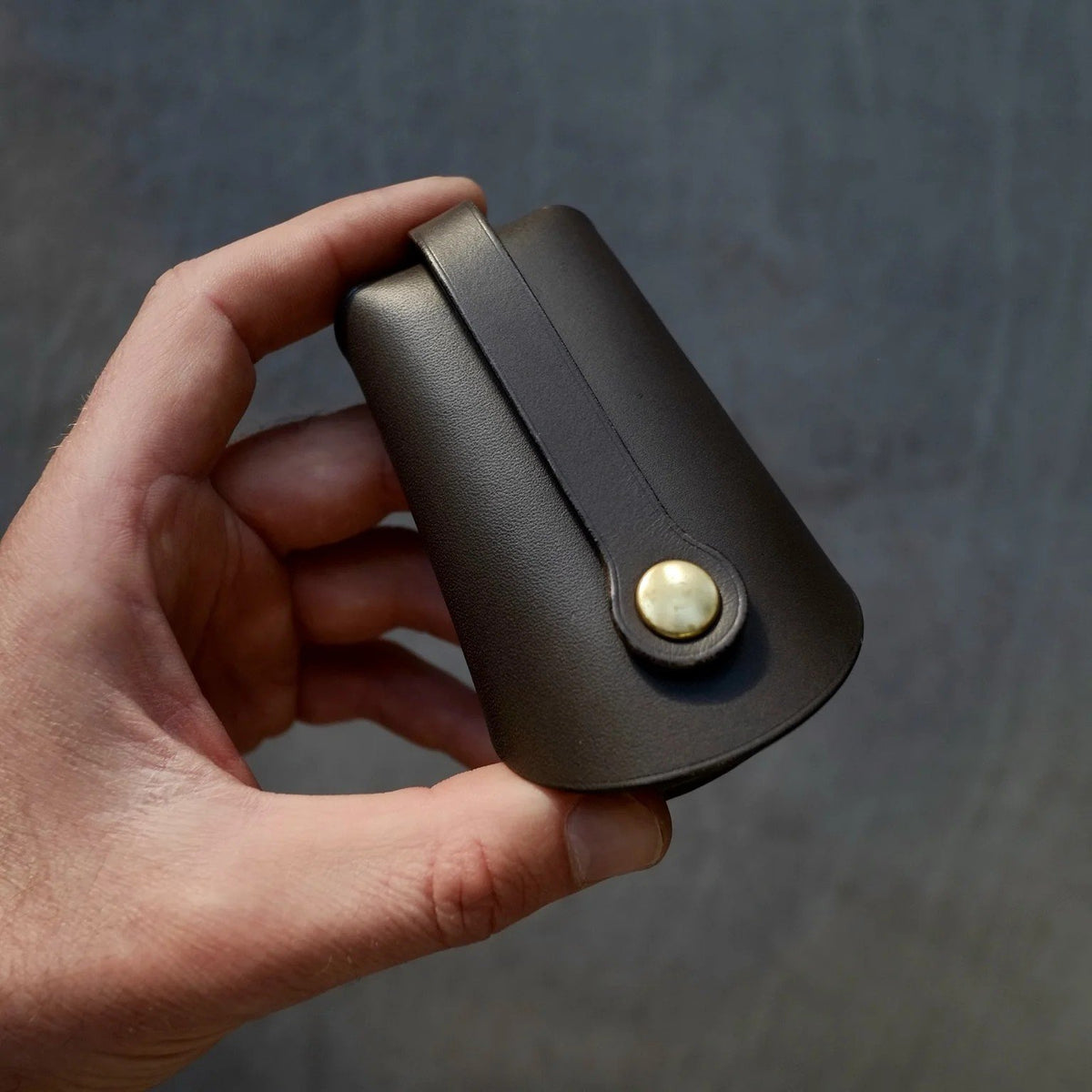 1. Mirgoods black folded keyholder in hand, showcasing premium vegetable-tanned leather and compact design