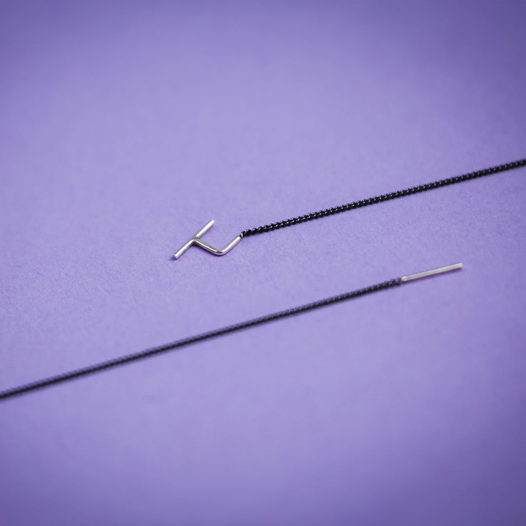 3. Close-up of Maarja Palu SWING 2 earrings on purple background, highlighting sleek design