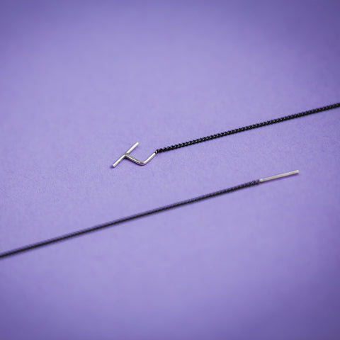 3. Close-up of Maarja Palu SWING 2 earrings on purple background, highlighting sleek design