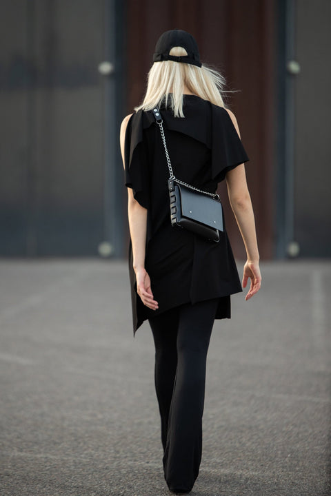 2. Woman in black outfit wearing PYKOK Agatha no.3 handbag with chain strap, shown from the back, outdoor setting
