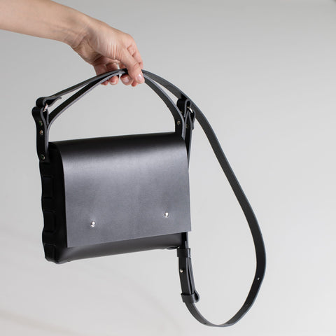 4. Close-up of PYKOK Agatha no.2 handbag in black leather, highlighting magnetic closure and short handle