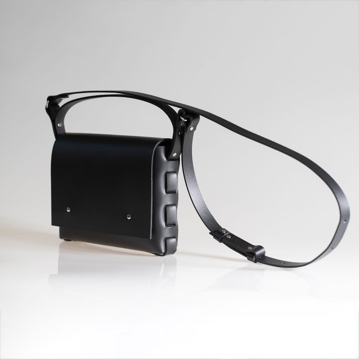 2. Studio shot of PYKOK Agatha no.2 handbag in black leather, showing adjustable strap and short handle