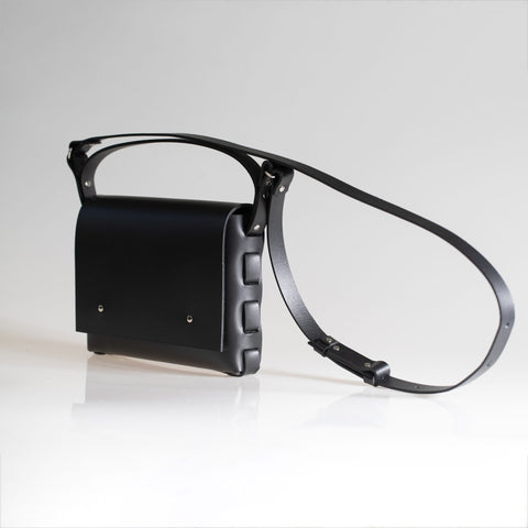 2. Studio shot of PYKOK Agatha no.2 handbag in black leather, showing adjustable strap and short handle