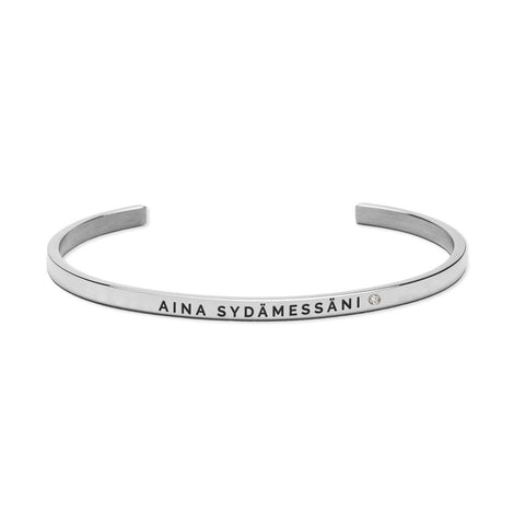 2. Olla AINA SYDÄMESSÄNI bracelet in silver, featuring engraved message, shown in studio