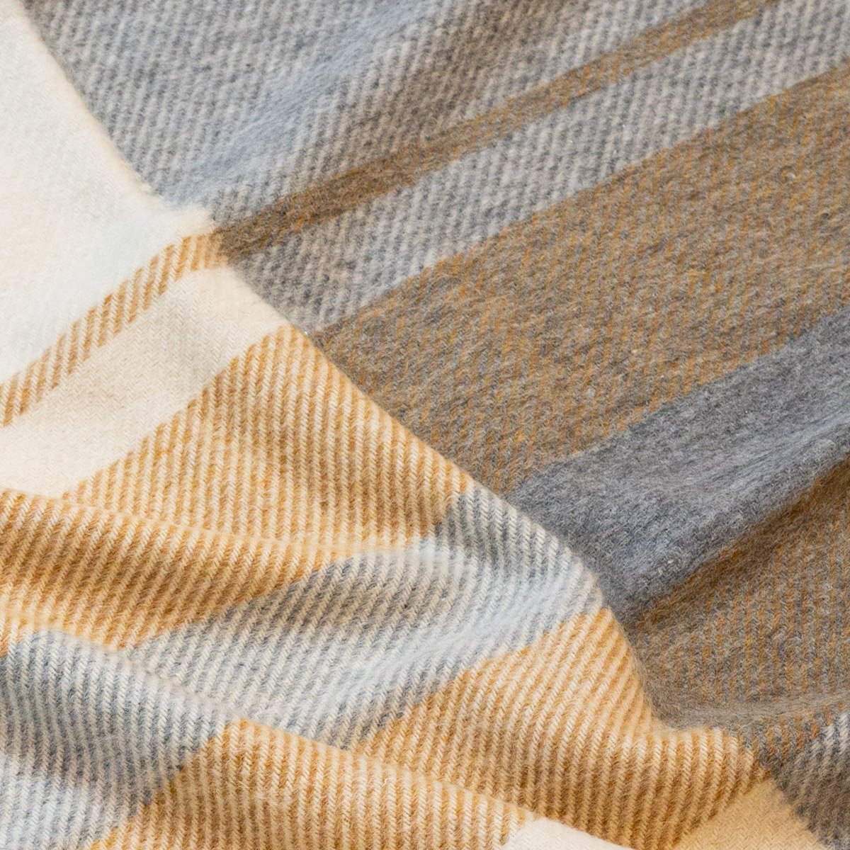 10. Close-up of Alpaka Natural Alpaca Wool Throw in Mustard/Silver, focusing on tartan pattern