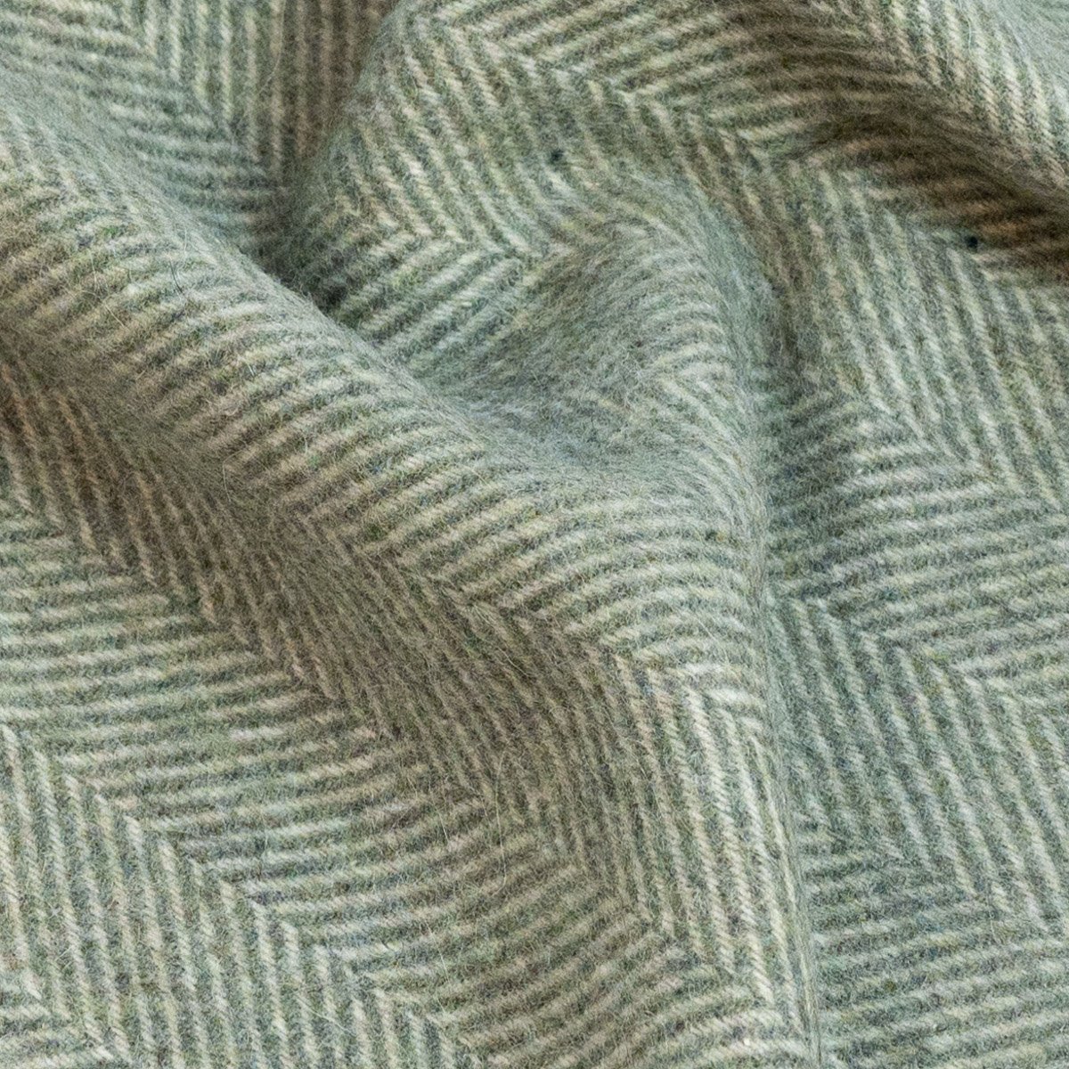 3. Close-up of green Alpaka wool throw showcasing fishbone design and texture