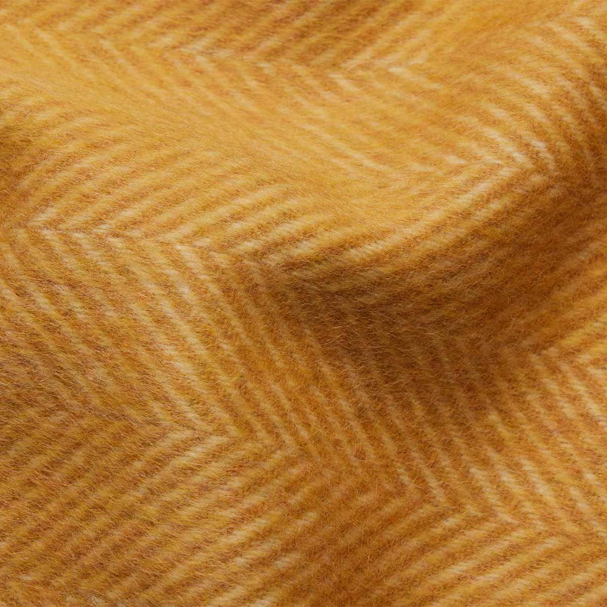 11. Close-up of mustard yellow Alpaka wool throw highlighting fishbone texture