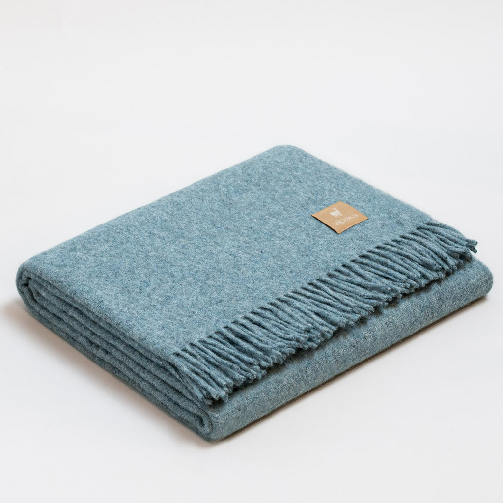 6. Light blue Alpaka natural alpaca wool throw with fringe detail, folded in studio
