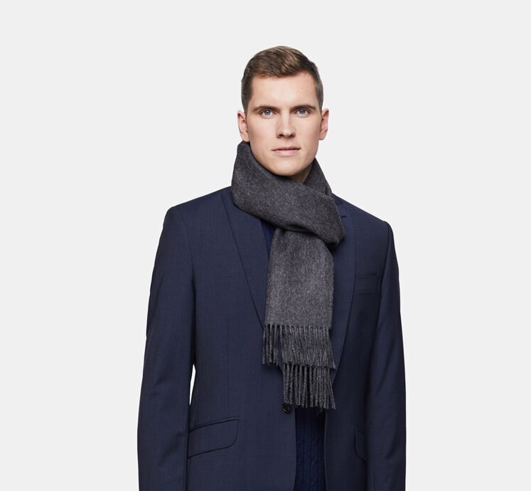 1. Men's charcoal Alpaka baby alpaca wool scarf styled with a navy suit in studio setting