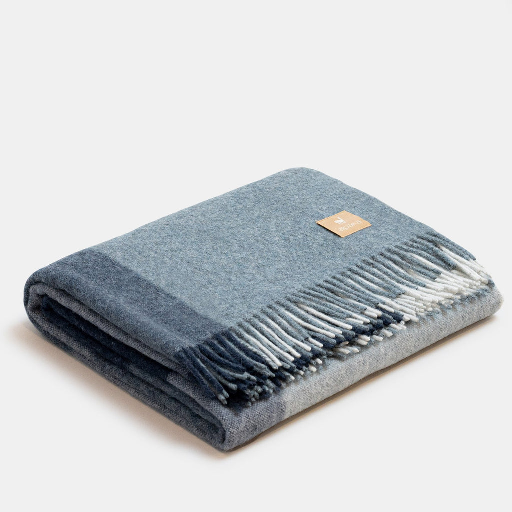 2. Studio image of blue Recycled Alpaca Wool Throw with classic check pattern and fringe detail