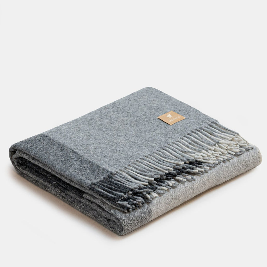 10. Studio image of grey Recycled Alpaca Wool Throw with classic check pattern and fringe detail