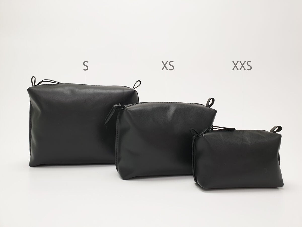 3. Zelma Kraft black leather cosmetic bags in sizes S, XS, and XXS, shown in studio setting