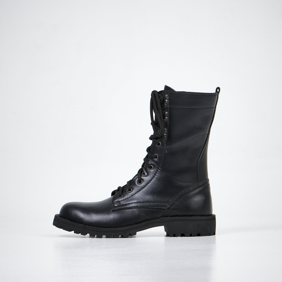 2. Aipi black leather boots with durable rubber sole, side profile in studio