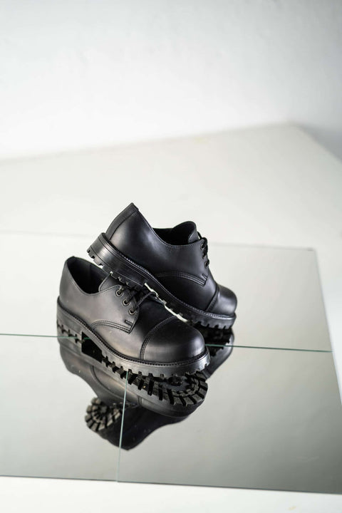 5. Studio shot of unisex black Samelin Widgets on reflective surface, highlighting sole and side