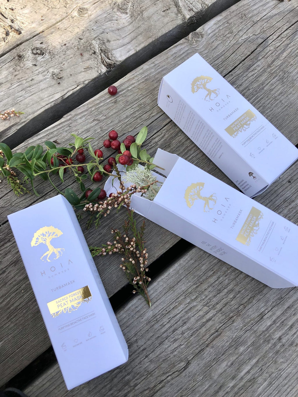 3. HOIA homespa Sacred Forest Peat Mask boxes with cranberries and greenery, emphasizing natural ingredients