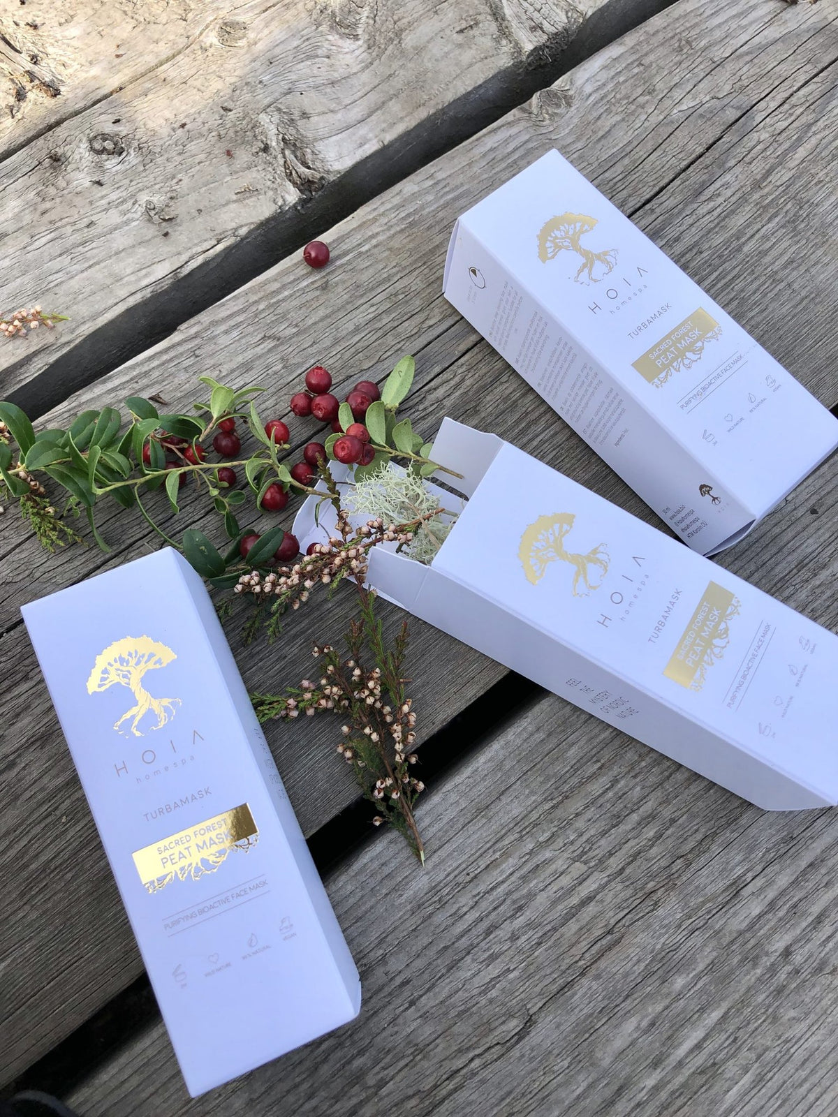 3. HOIA homespa Sacred Forest Peat Mask boxes with cranberries and greenery, emphasizing natural ingredients