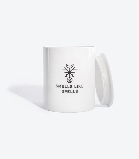 1. Smells Like Spells scented candle in white porcelain container with lid, featuring mystical logo
