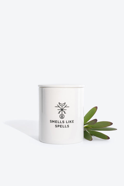2. Smells Like Spells Scented Candle JUDGEMENT in white porcelain container with green leaves, studio setting