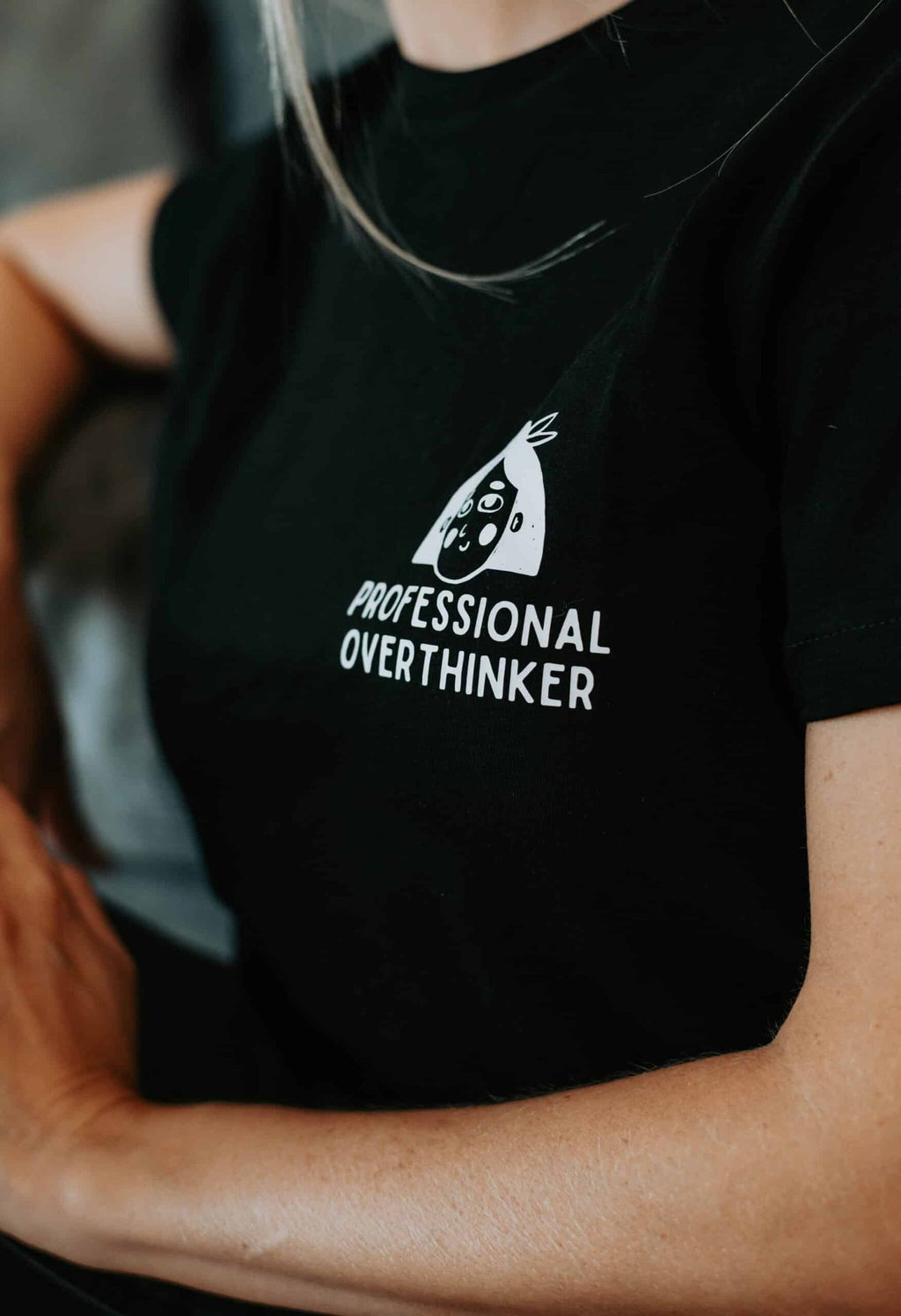 4. Close-up of black Professional Overthinker T-shirt by Black Giraffe Brand, highlighting logo and text