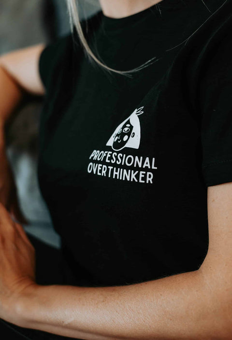 4. Close-up of black Professional Overthinker T-shirt by Black Giraffe Brand, highlighting logo and text